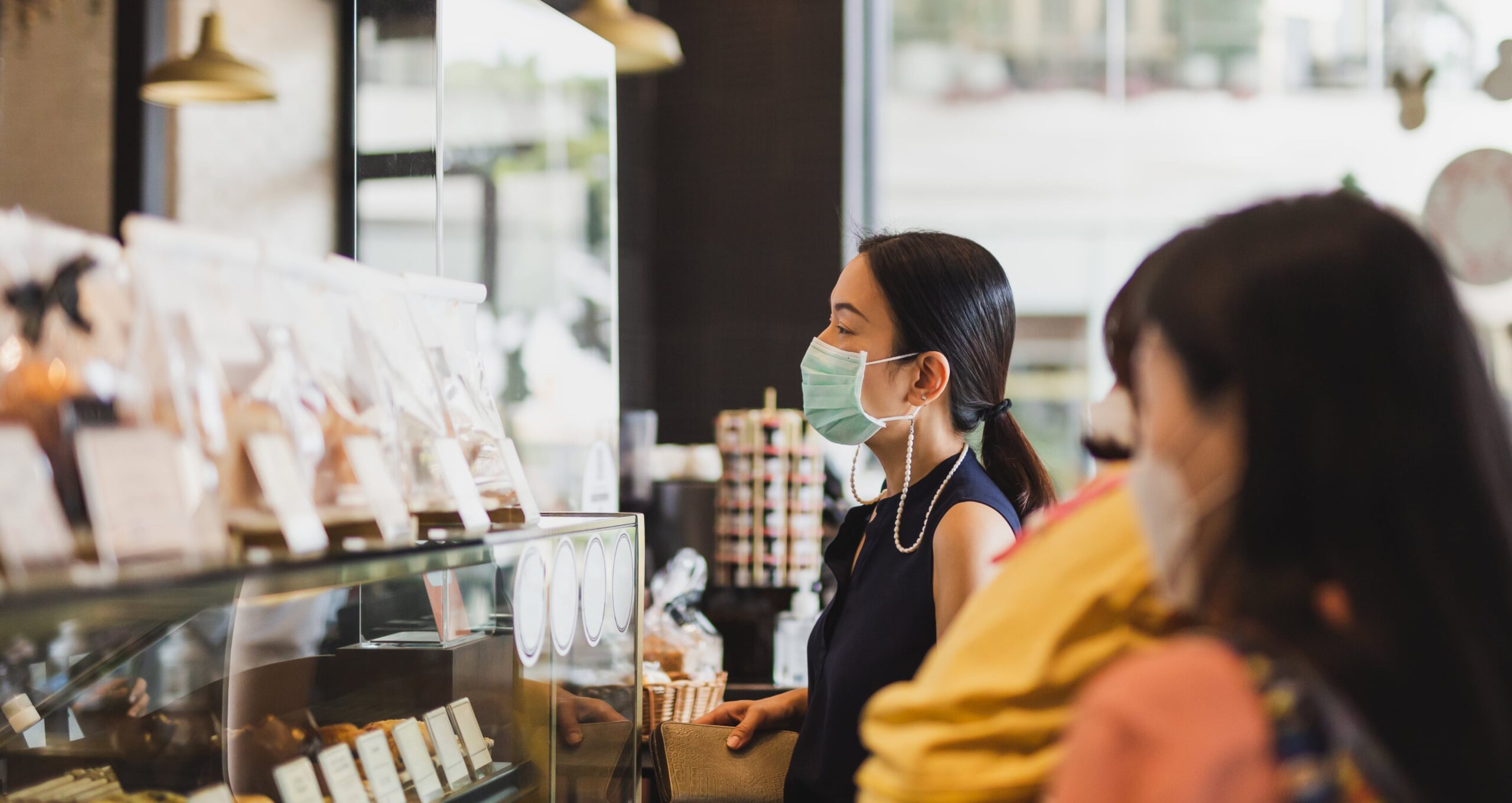 women-medical-mask-ordering-drink-cafe-counter-min-min